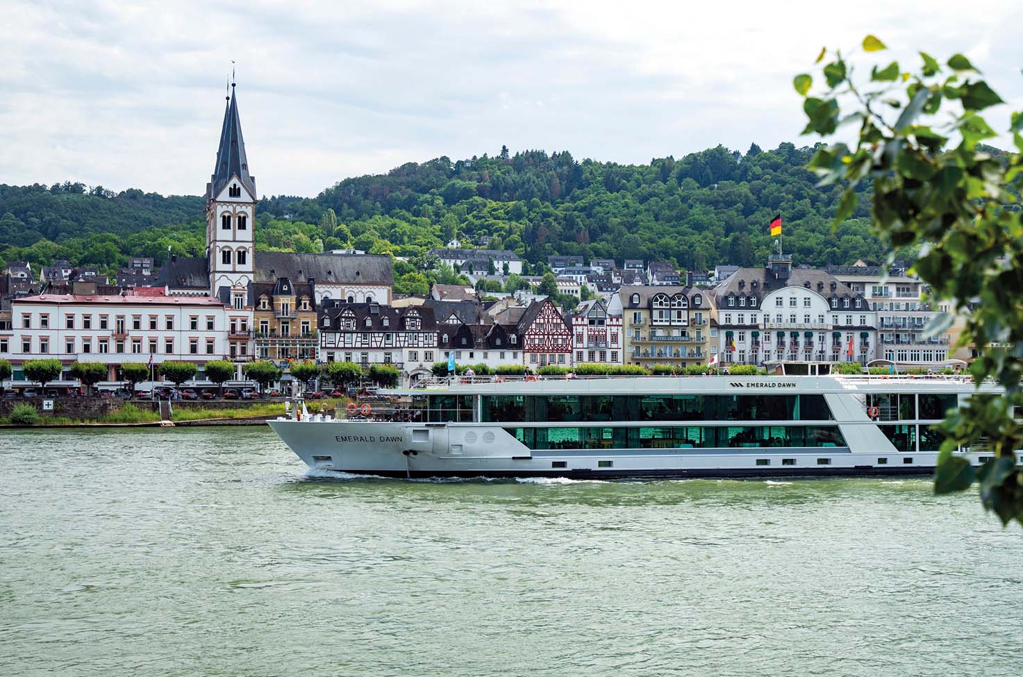 Luxury river cruise ship sailing past a charming town on the Rhine Gorge, along the Rhine river
