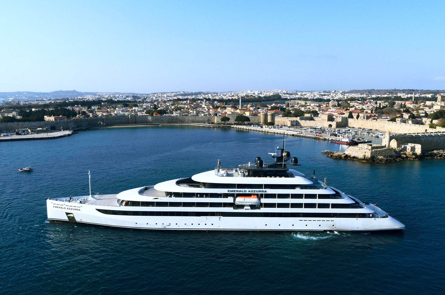 Luxury yacht on the coast of Rhodes in Greece, under a blue sky, with the waters a deep blue