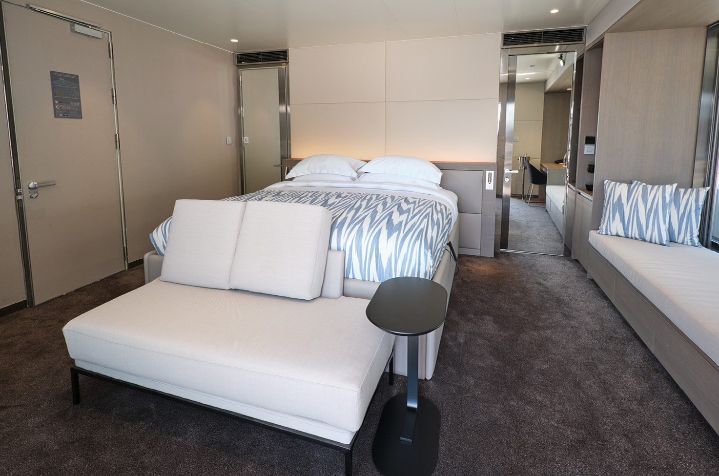 Suite on board a luxury yacht with double bed and balcony doors shown