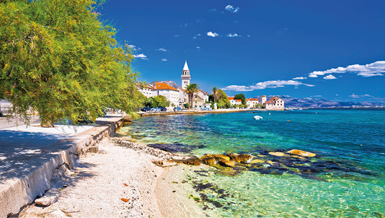 A coastal town in Croatia on a bright sunny day, along the shores of the crystalline waters