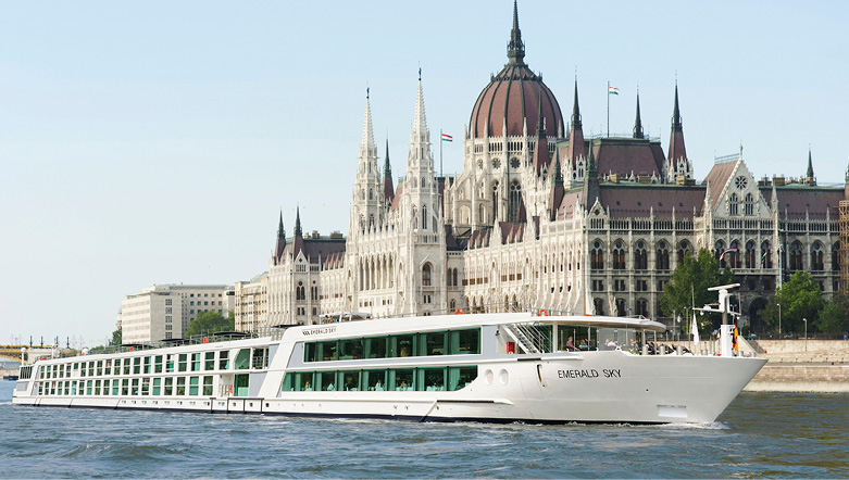 Luxury cruise ship sailing the Danube River past the Hungarian Parliament Building in Budapest