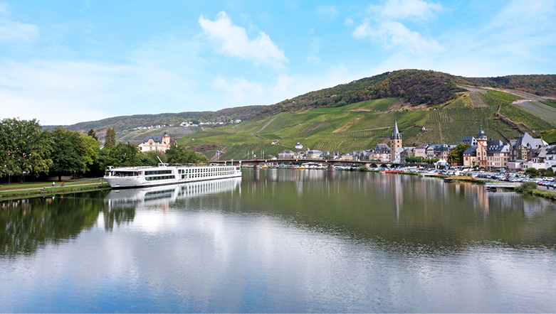 Luxury river ship docked in Bernkastel, Germany, with the landscape reflected in the water