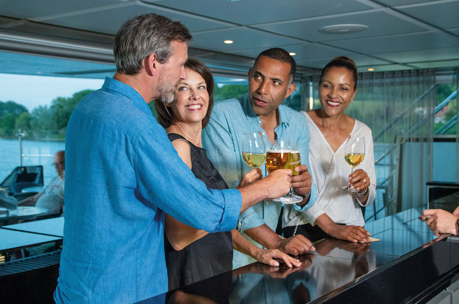 Friends enjoying a drink together at the bar on board a luxury river ship 
