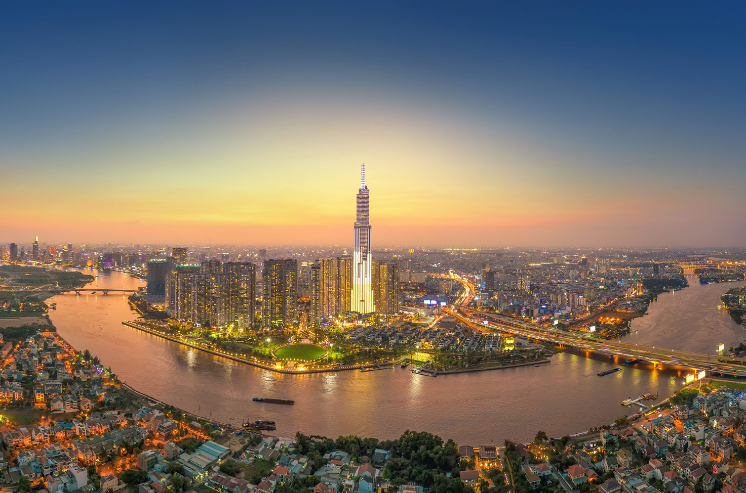 Ho Chi Minh City’s buildings lit up as the sun sets along the Mekong River