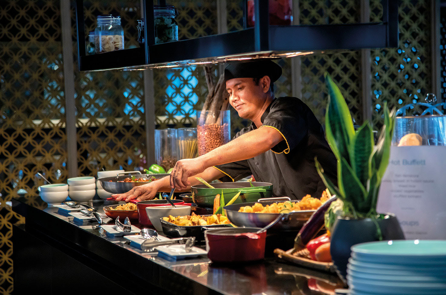 Expert chef preparing Southeast Asian cuisine for a buffet in on board restaurant