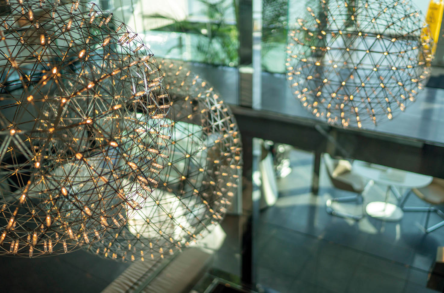 Intricate ball-shaped lighting hanging from the ceiling of a bright and spacious reception