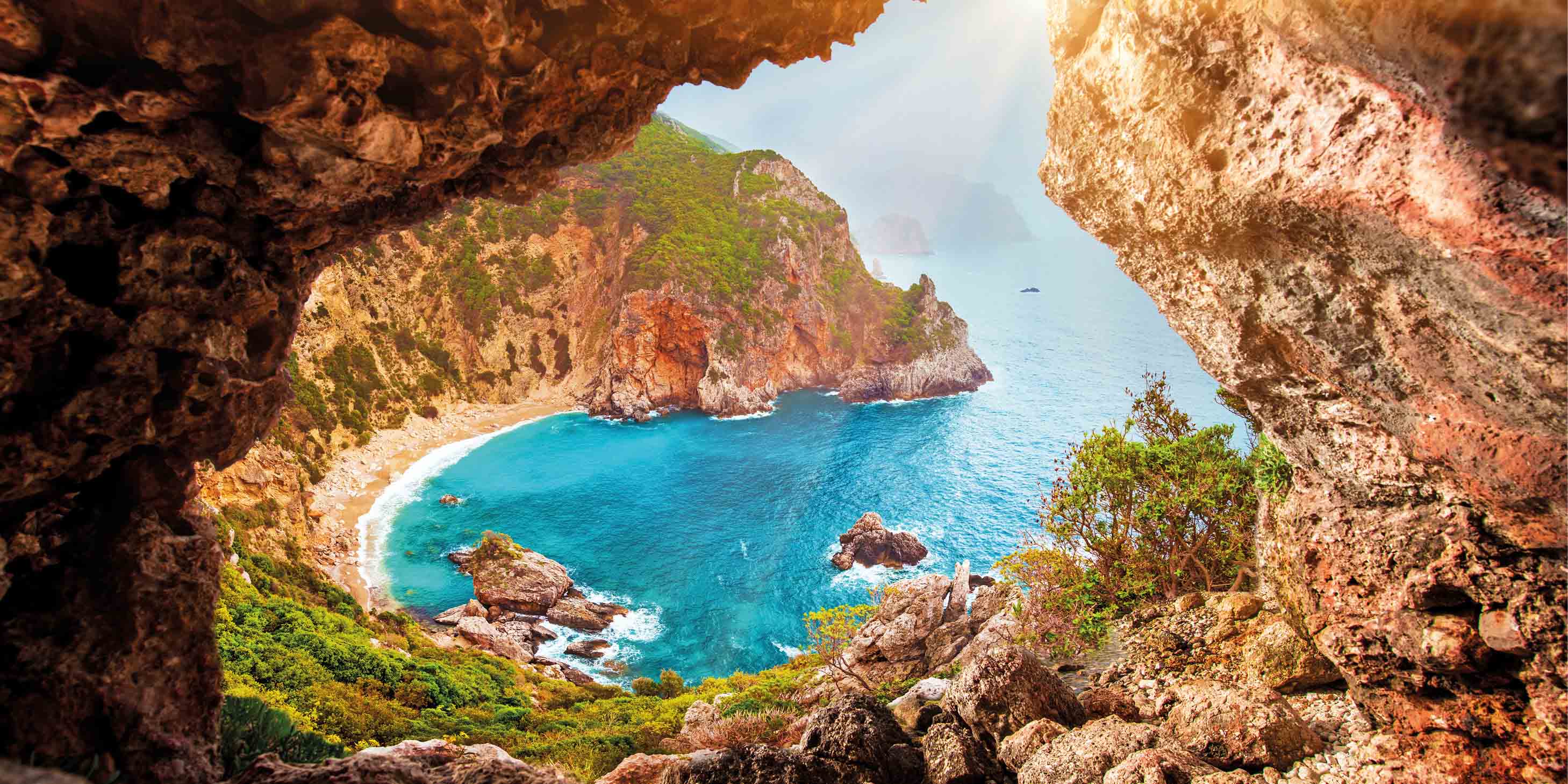 a view from a cave of a beach and a body of water