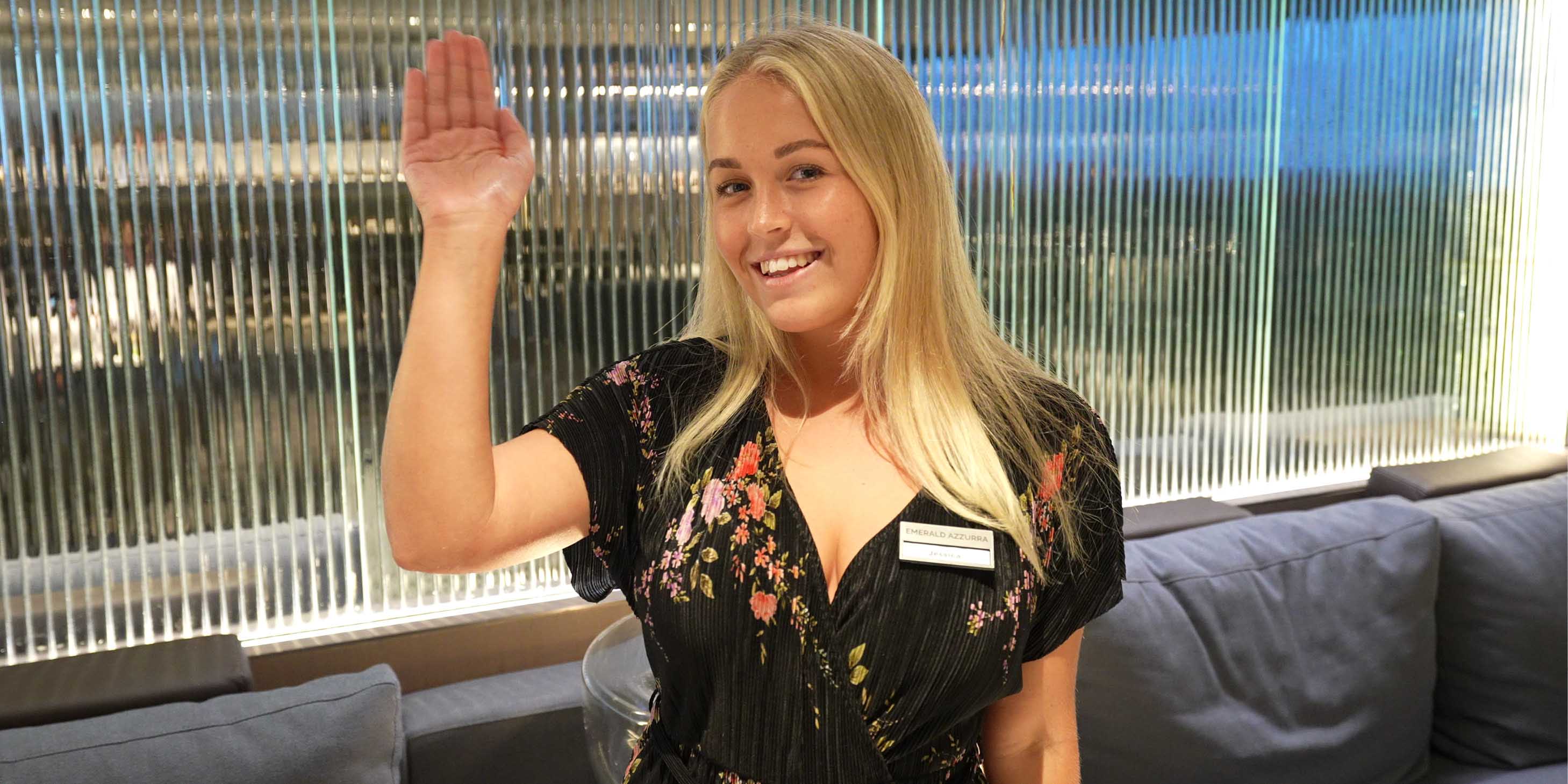 Smiling crew member waving on board an Emerald Cruises luxury yacht cruise